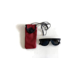 Black sunglasses with a red and black case on a white background