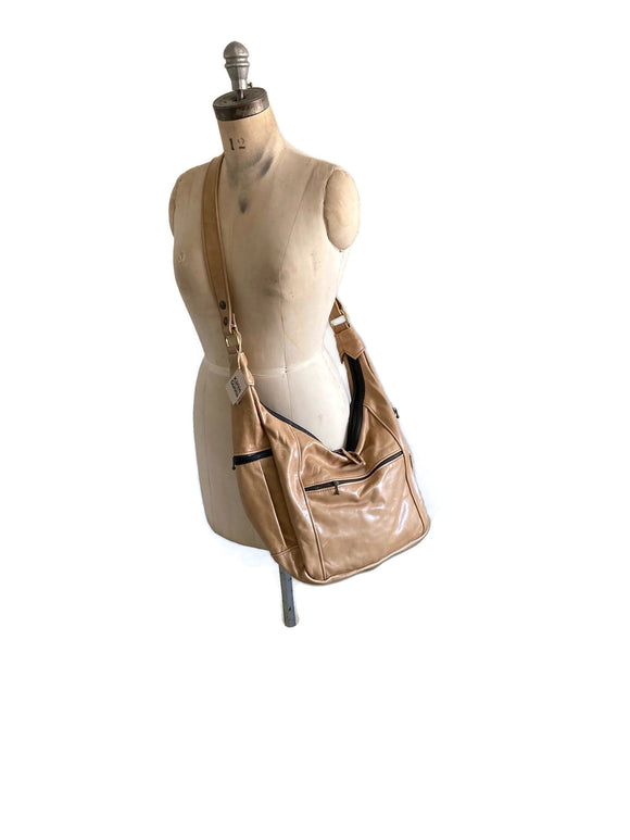 Smooth tan handbag on a mannequin against a white background