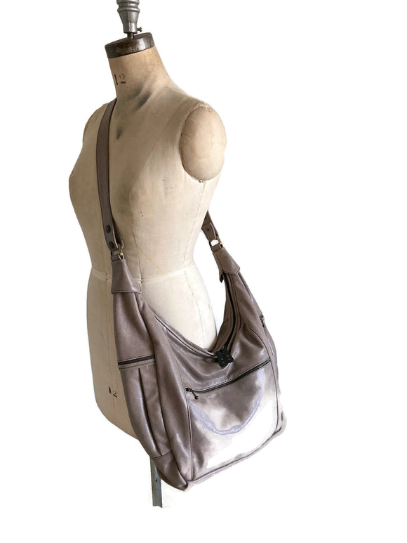 Taupe handbag on a mannequin against a white background