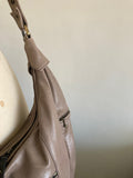 Silver handbag on a mannequin against a white background